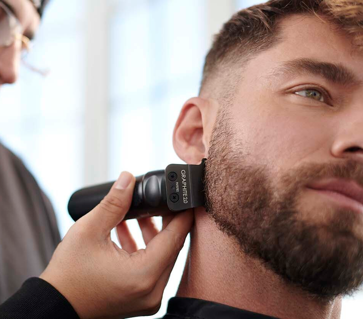 hombre con barba con cortadora de cabello en negro