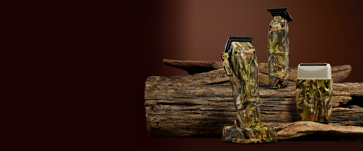Three camouflage‑patterned hair grooming tools&mdash;a shaver, a hair clipper, and a trimmer&mdash;displayed on a rustic wood surface surrounded by leaves.