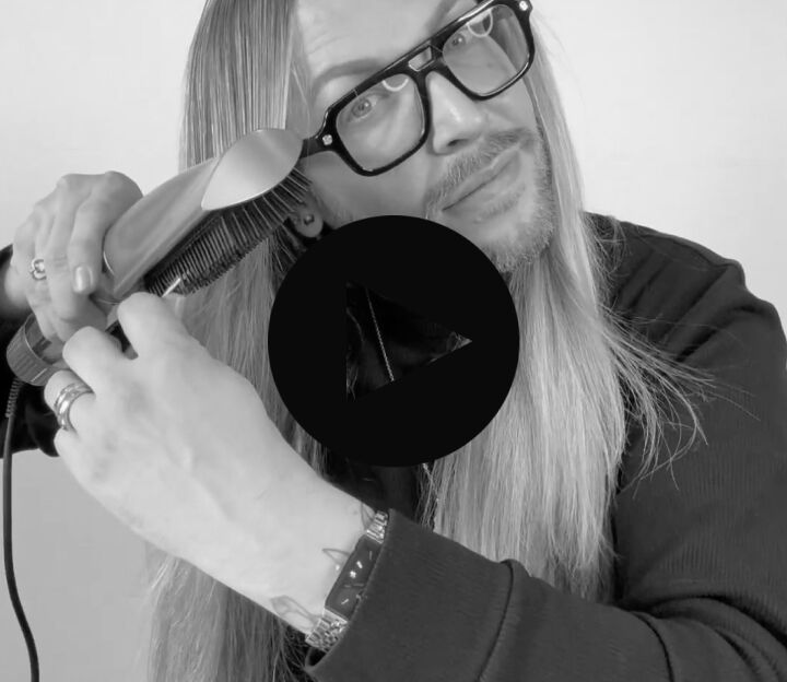 man with long hair using the style switch paddle brush to help smooth and brush through his hair