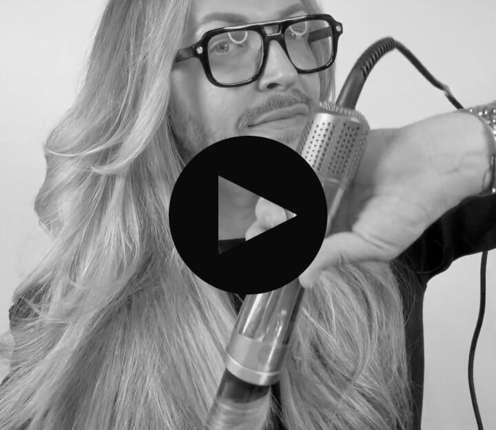 man with long hair using the style switch air curling barrels attachment to curl his hair