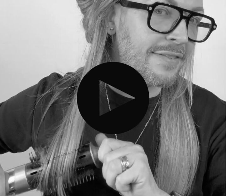 man with long hair using the style switch round brush to add waves to his hair