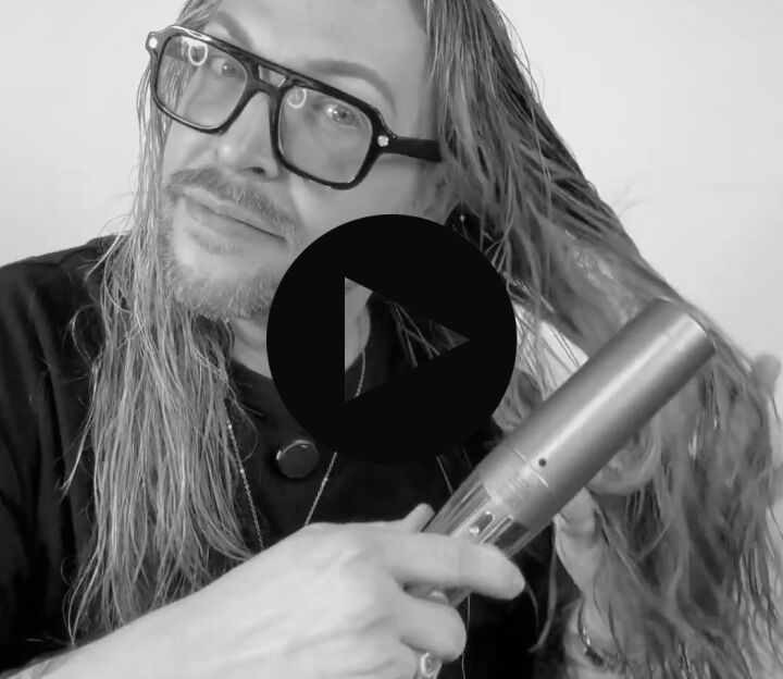 man with long hair using the style switch adjustable concentrator to dry his wet hair
